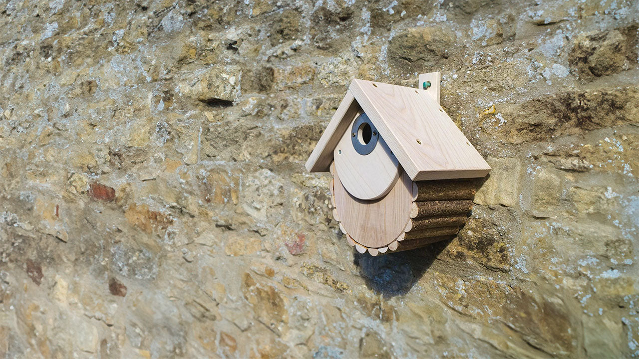 Light wooden nest box on a brick wall