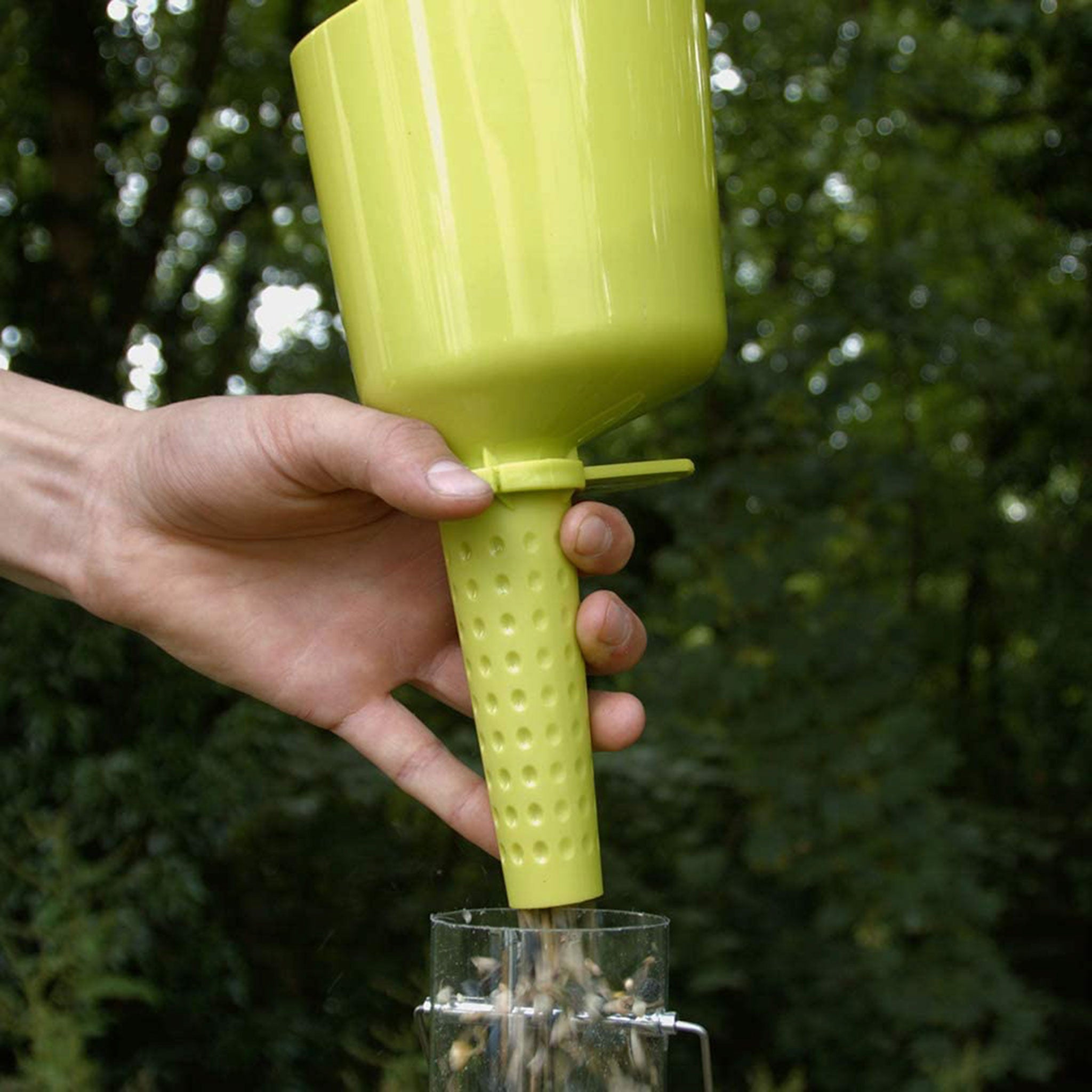 Green scoop filling a feeder